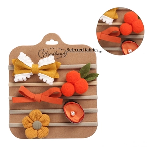 Detail view of 5-piece infant headband set featuring bows and flowers on elastic bands