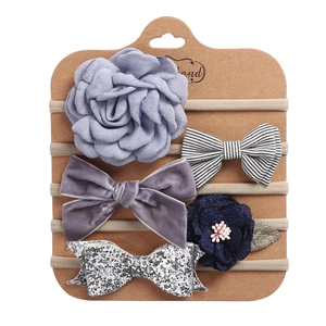Detail view of 5-piece baby headband set with fabric flowers and glitter bows on card