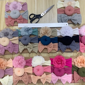 Close-up of three-piece baby headband set with floral and bow details on card