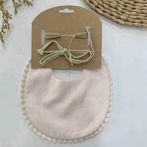 Détail du bavoir pour bébé avec bordure en dentelle et bandeau tissé assorti