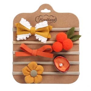 Detailed macro view of 5-piece infant headband set with bows and pearls on card