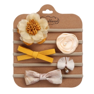Detail of 5-piece baby headband set with floral and bow designs on kraft display card