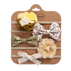 Detail of 5-piece baby headband set featuring lace bows and floral accents on card