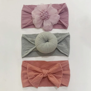 Detailed set of three baby headbands featuring purple tulle flower and pink bow design