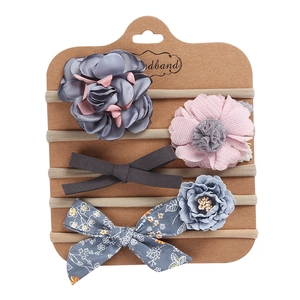 Detailed set of 5 baby headbands with floral and bow designs on a display card