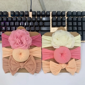 Detail of 6-piece baby headband set with fabric flowers and bows on display card