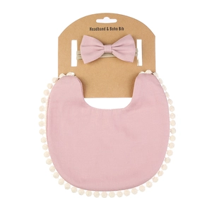 Détail du bavoir rose pour bébé avec bordure pompon et bandeau à nœud assorti