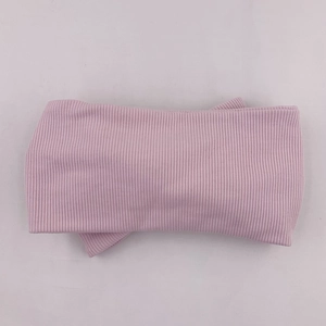 Detail view of baby light pink ribbed knit headband with elastic texture and soft fabric