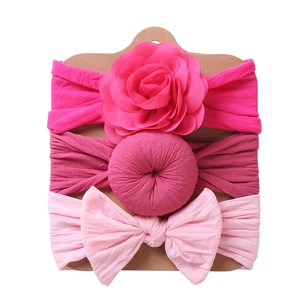 Detailed set of 3 elastic baby headbands with pink fabric flowers and bows on display card