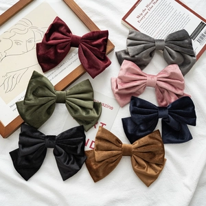 Elegant large velvet bow hair clips in multiple colors on a vintage aesthetic background
