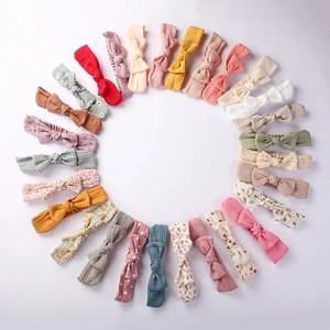 Flat lay of soft cotton baby headbands in various colors and floral patterns