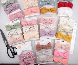 Detailed view of 3-piece baby headband set with rabbit ears and bows on display card
