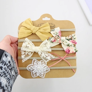Detail view of 5-piece baby headband set with lace bows and flowers on nylon bands