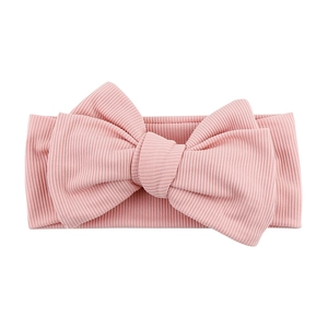 Close-up of pink ribbed baby headband featuring a large soft bow and elastic knit texture