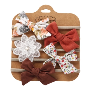 Detail of 5-piece handmade baby nylon headbands with lace flowers and bow ties on card