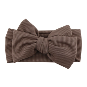 Close-up of dark brown ribbed knit baby headband with a large decorative bow detail