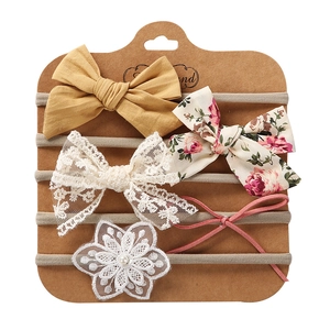 Detail of 5-piece baby headband set with lace, bows, and pearl flowers on card