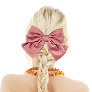 Detail of pink velvet bow hair clip worn on a blonde braided hairstyle with back view