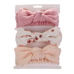 Detailed macro view of 3-piece baby bow headbands featuring floral and solid patterns