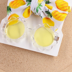 Detail von Blumen-Sonnenbrille mit Ananas-Stirnband-Set auf weißer Markenkarte
