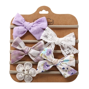 Close-up of 5-piece baby headband set with lace bows and pearls on display card