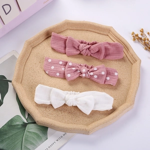 Detailed set of three cotton baby bow headbands in pink, white, and polka dot patterns
