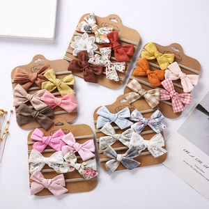 5-piece set of handmade baby nylon headbands with floral bows on display cards