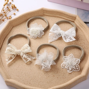 5-piece baby headband set with white lace bows and flowers on soft grey nylon bands