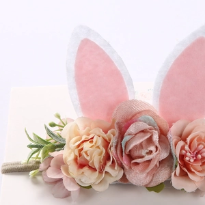 Detailed macro view of pink felt bunny ears with artificial roses on grey elastic headband