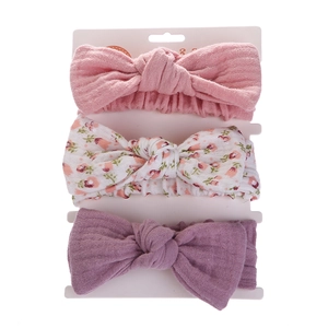 Three-pack baby headbands featuring pink, floral, and lilac bow designs on display card