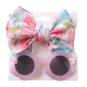 Detailansicht von Blumen-Stirnband und lila Blüten-Sonnenbrille auf der Displaykarte