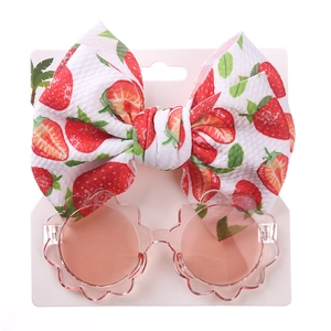 Detail von Kinderblumen-Sonnenbrille und weißem Erdbeer-Stirnband-Set auf Displaykarte