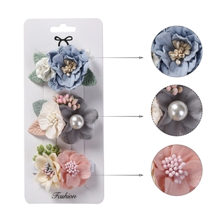 Détails de trois pinces à cheveux fleurs en tissu avec perles sur carte de présentation