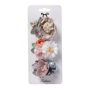 Détail d'un ensemble de 3 barrettes à fleurs en mousseline avec perles sur carte de support