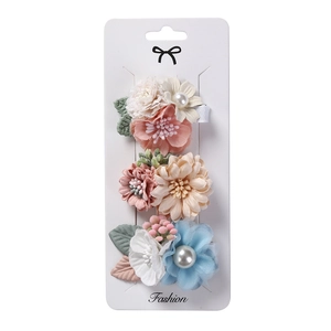 Détail de l'ensemble de barrettes à fleurs faites main avec pétales en mousseline et perles