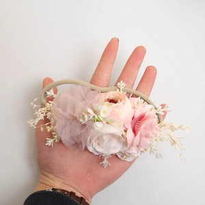 Dettaglio della fascia floreale neonata con rose di stoffa rosa e fascia elastica in nylon