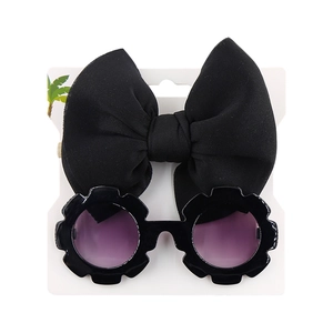 Detail of flower shaped kids sunglasses and black bow headband on display card