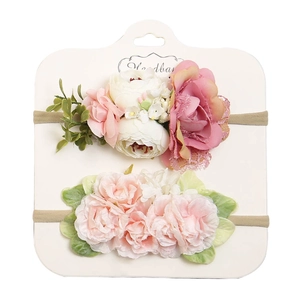 Dettaglio delle fasce per neonati floreali rosa e beige su carta con nylon