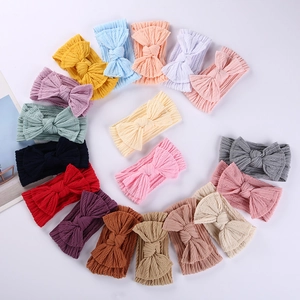 Vue à plat de 18 bandeaux bébé colorés en maille gaufrée avec de grands nœuds en cercle
