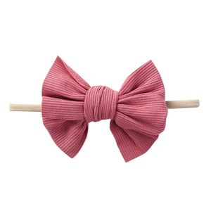 Dettaglio di un fiocco in morbido cotone a coste su fascia elastica in nylon per neonati