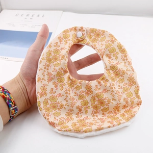 Detail of yellow floral baby bib featuring soft plush edges and a secure snap closure