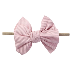 Dettaglio fascia per neonati con grande fiocco rosa in tessuto a costine su corda in nylon