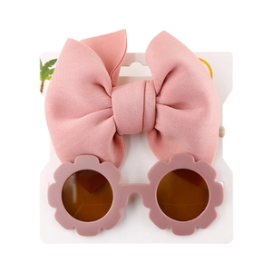 Detail view of pink bow headband and flower shaped sunglasses on display card