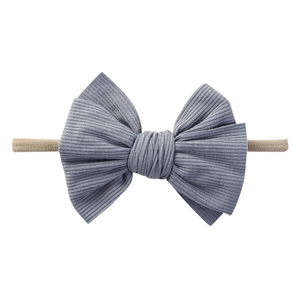 Dettaglio fascia neonata in cotone a coste blu-grigio con fiocco e cinturino in nylon