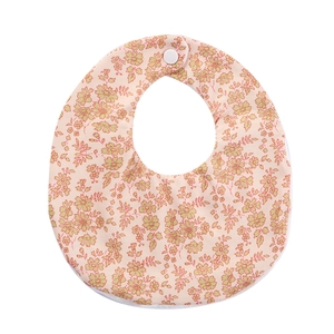 Detail of floral baby bib with soft pink cotton fabric and white snap closure