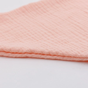 Nahaufnahme von rosa Baby-Mulltuchgewebe mit weicher Textur und sauberer Nahtführung