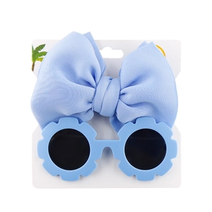 Detail of light blue flower sunglasses and matching large bow headband set for kids