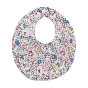 Detailed macro of floral baby bib with double snap fasteners and soft cotton fabric