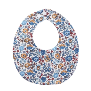 Detail of floral cotton baby bib featuring adjustable snap buttons and soft printed fabric