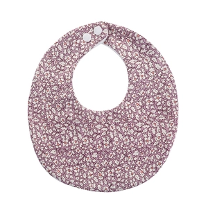 Detail of baby cotton bib with purple floral print and dual white snap fasteners